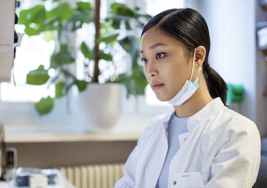woman wearing mask under her chin, looking offscreen